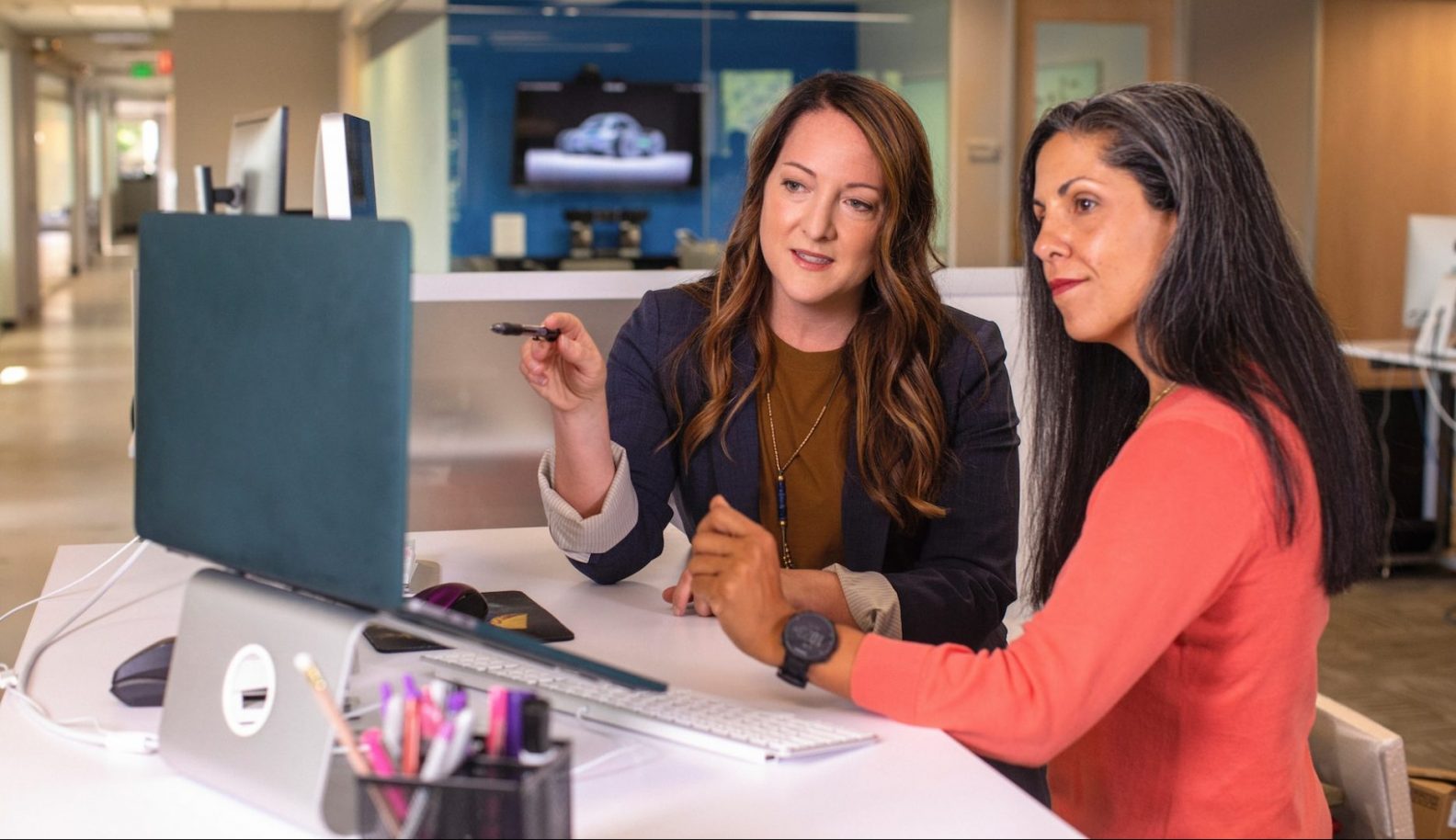 Manager explaining work to employee on the monitor
