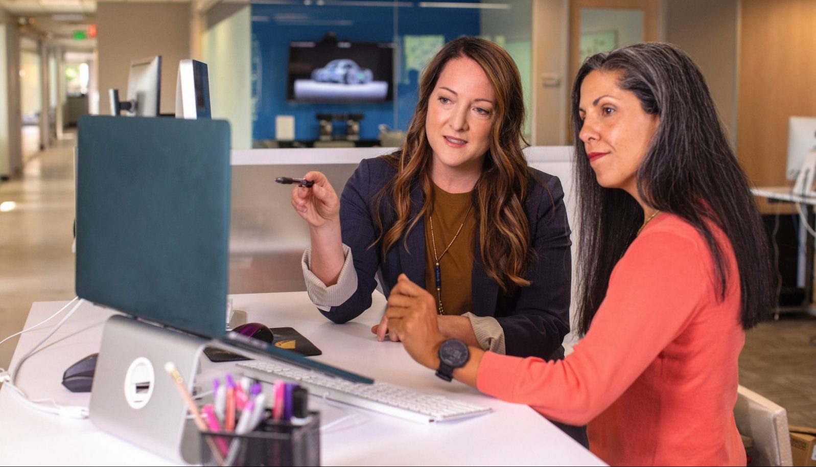 Two colleagues discussing something on a laptop