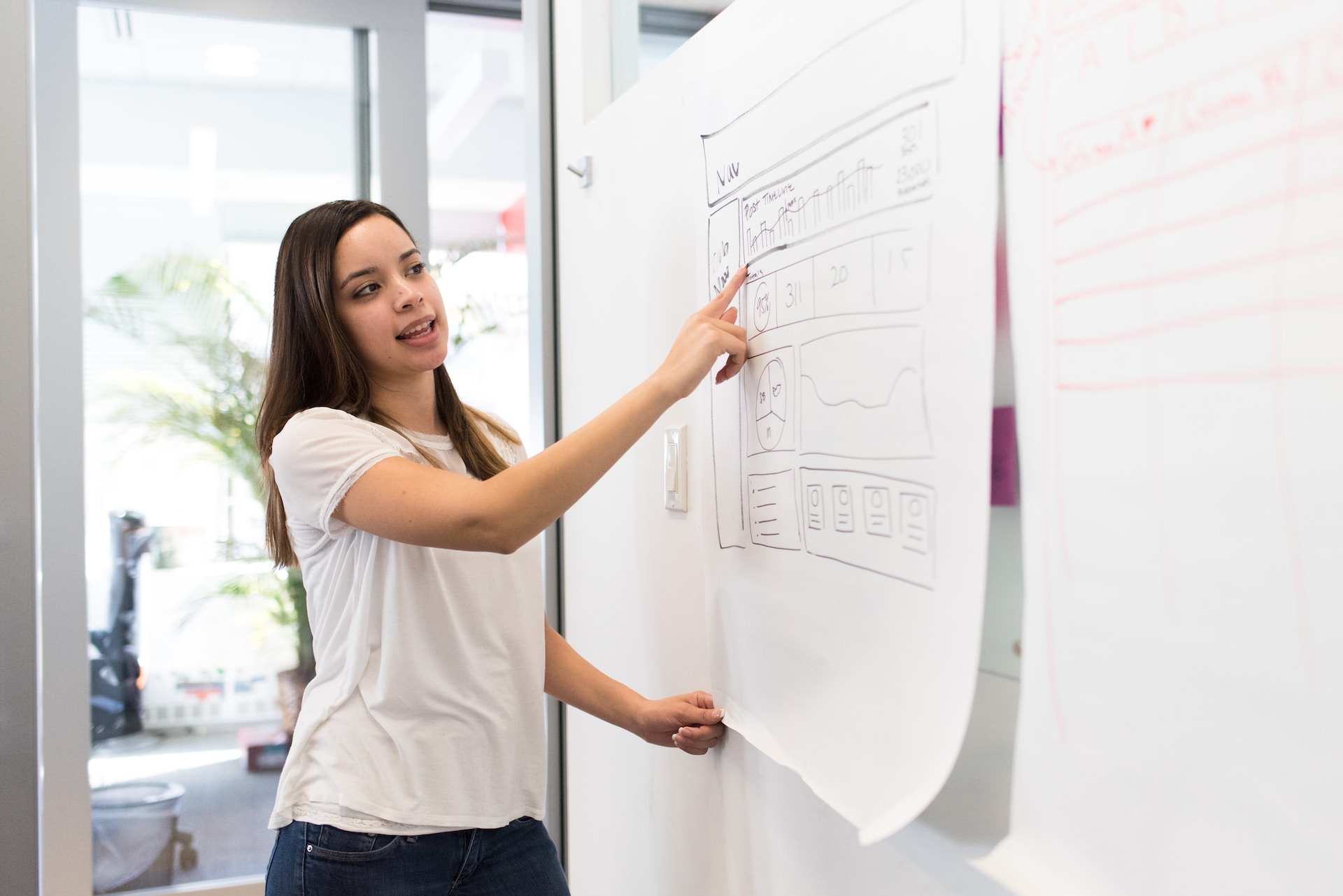 Woman standing and pointing to visuals on a board