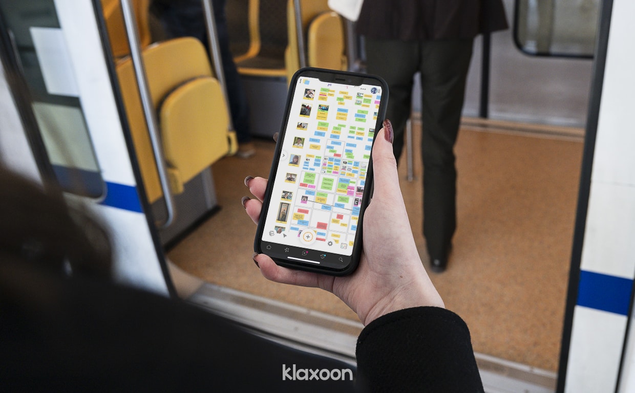 Une personne en déplacement dans les transports en commun, en train de préparer ses idées pour sa prochaine Matinale en équipe. | Klaxoon