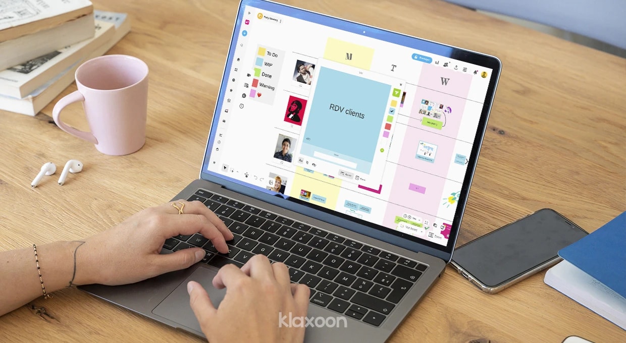 Une personne travaillant sur un ordinateur qui affiche un Board où plusieurs membres de son équipe ont partagé des idées et des documents. | Klaxoon