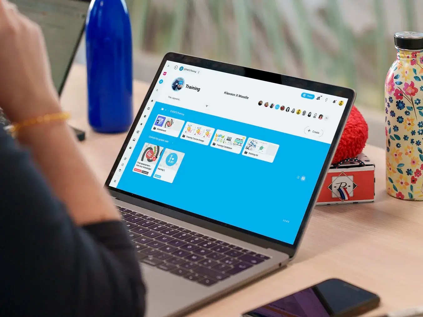 Klaxoon training and development dashboard on laptop screen with interactive collaboration widgets.