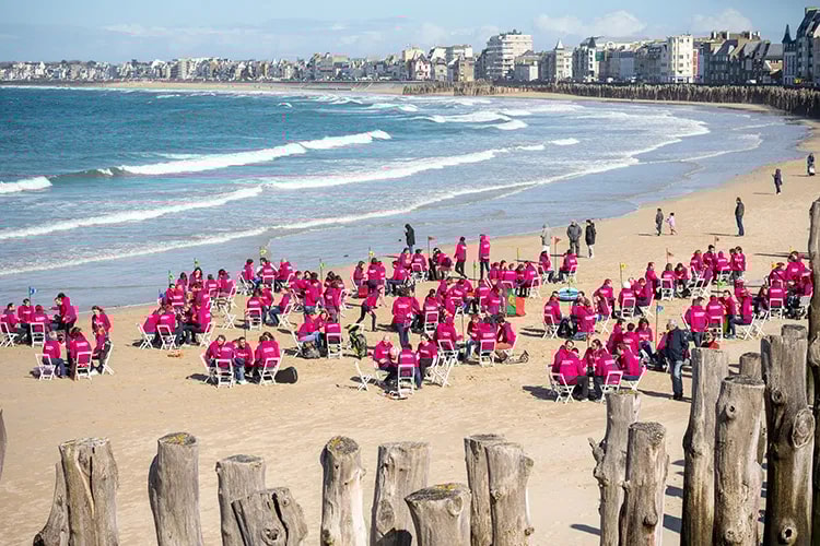 Une centaine de personnes réunies par groupes de 5 pour échanger sur une plage