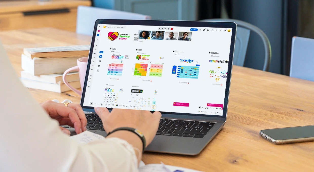 Une personne travaillant sur un ordinateur qui affiche le Board “Service client” complété, avec plusieurs autres personnes connectées en visio. | Klaxoon