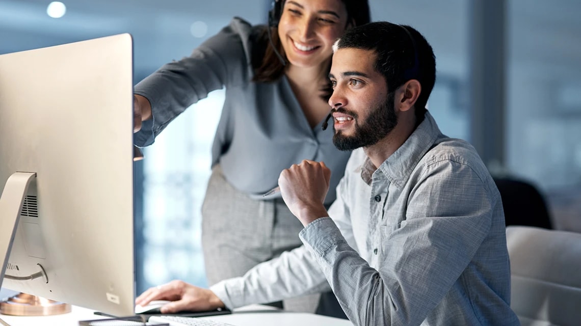 Deux personnes qui discutent devant un écran d'ordinateur. | Klaxoon