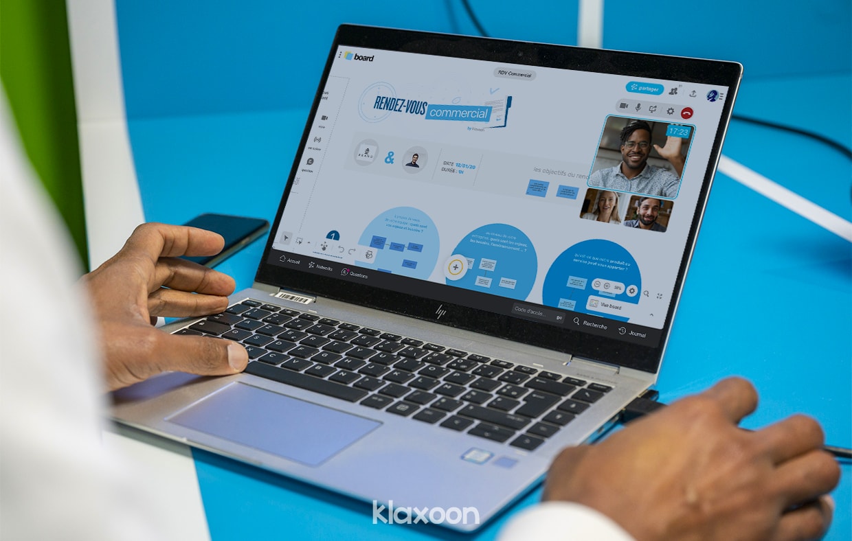 Une personne travaillant à distance avec son équipe sur ordinateur, avec un Board d'après un template Rendez-vous commercial. | Klaxoon