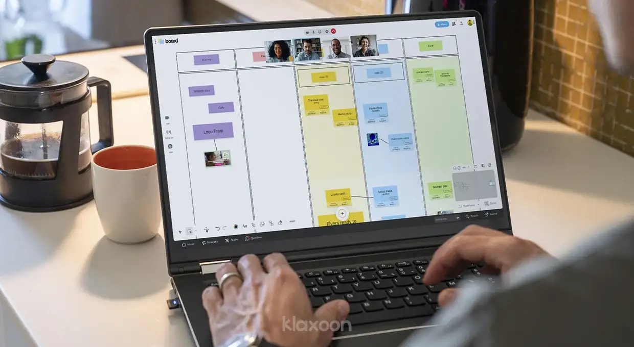 A person working on the Klaxoon platform while connected to a Board, with other people connected remotely by videoconference. | Klaxoon