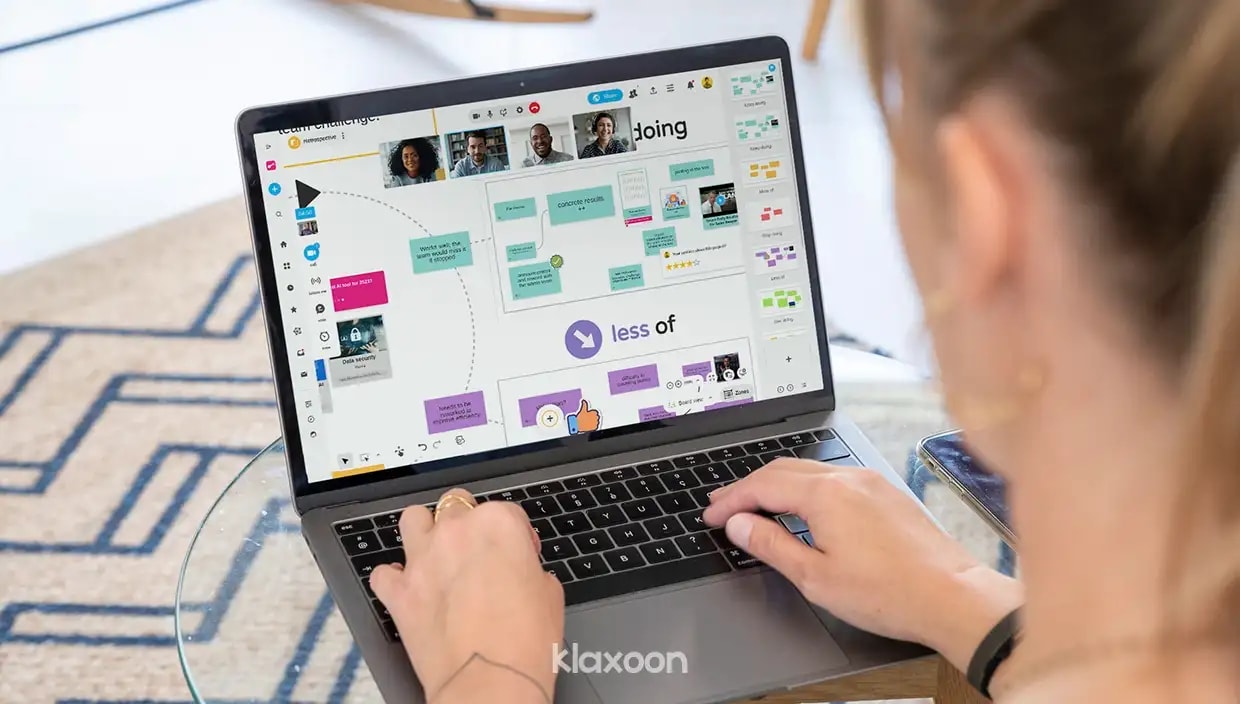 A person working remotely on a computer displaying a Retrospective Board divided into several zones, visible on the right. | Klaxoon
