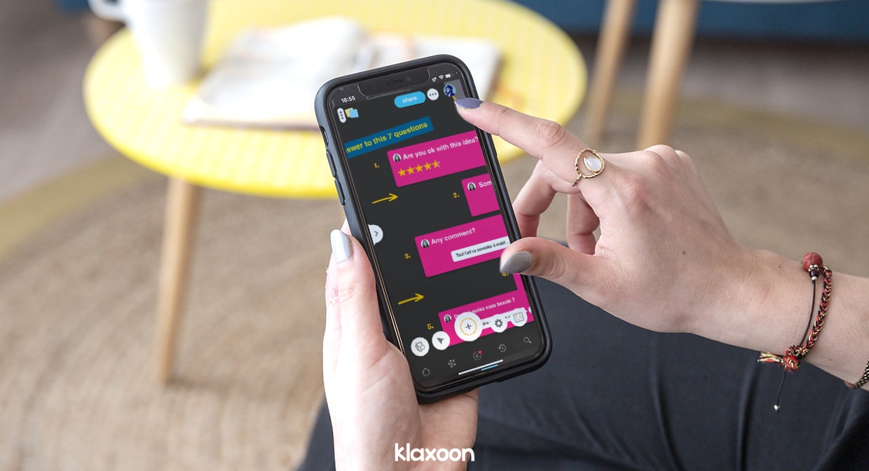 A person using a smartphone to anser Questions on a Board. | Klaxoon