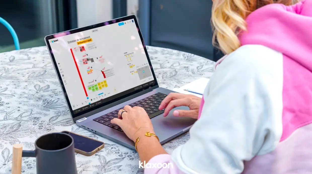 A person working remotely on a laptop displaying a “Conducting a job interview” template. | Klaxoon