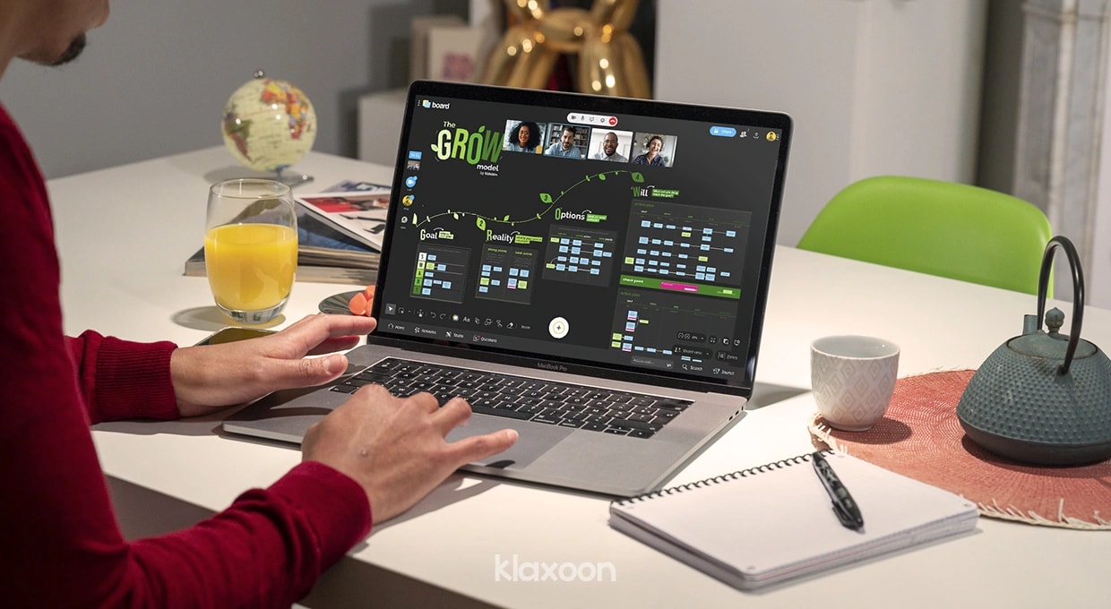 A person working remotely on a laptop displaying a GROW template. | Klaxoon