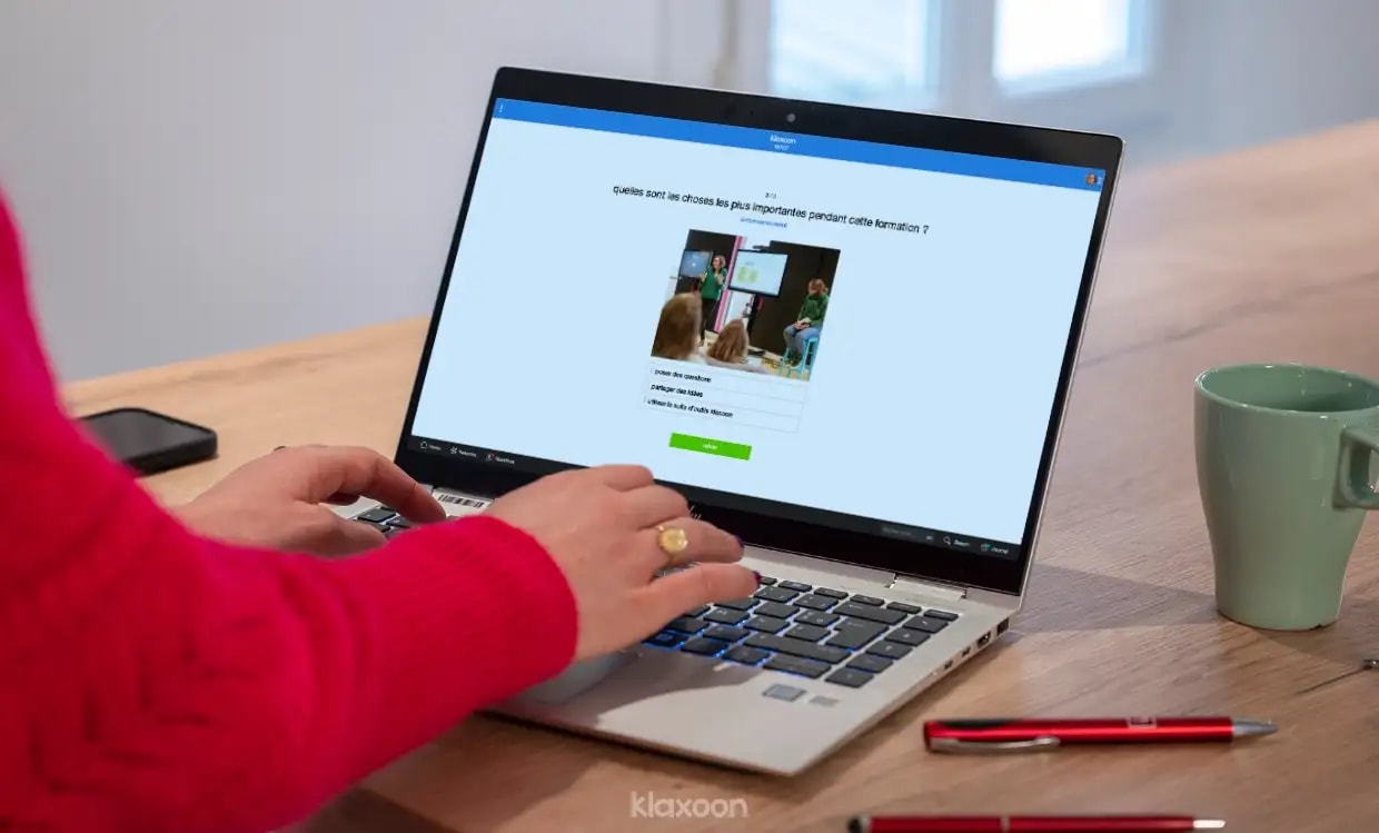 Une personne travaillant sur un ordinateur qui affiche un Quiz. | Klaxoon