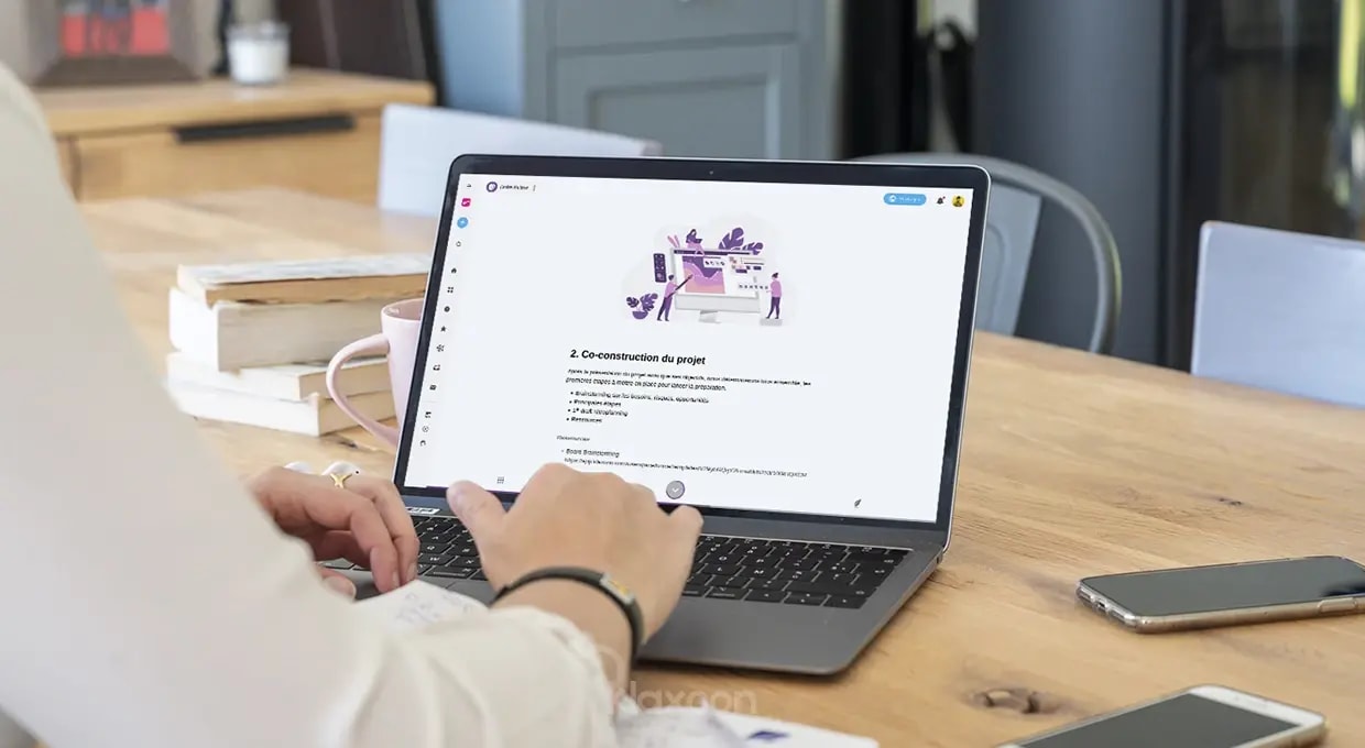 Une personne travaillant sur un ordinateur qui affiche un modèle d’ordre du jour de réunion. | Klaxoon