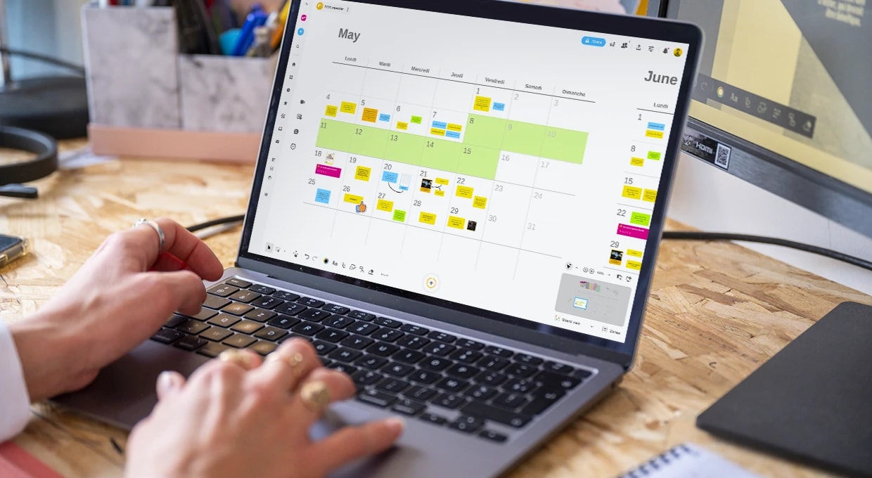 Une personne travaillant sur un ordinateur qui affiche un Board Calendrier 2026 rempli sur la période d’un mois. | Klaxoon