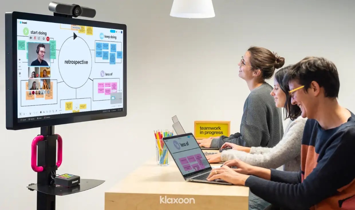 A collaborative meeting with people participating remotely and from the office. | Klaxoon