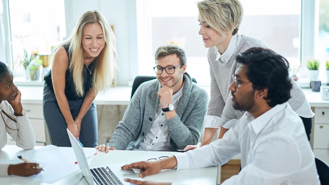 Plusieurs personnes qui discutent autour d'un écran d'ordinateur. | Klaxoon