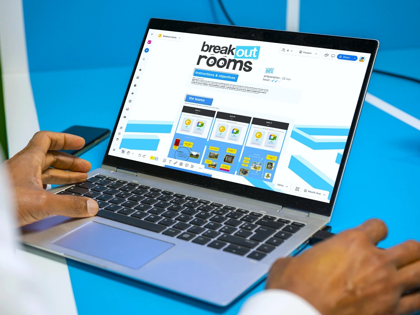 Team conducting hybrid work meeting around table with laptops and tablets.