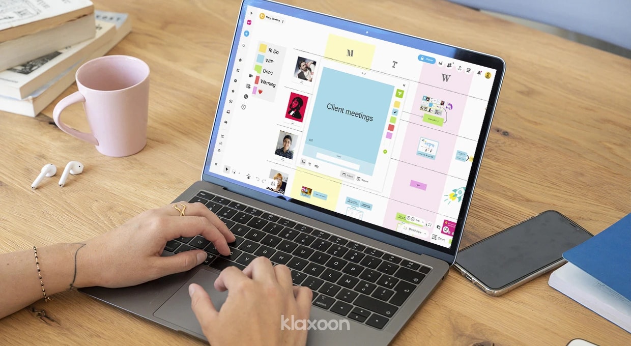 A person working on a computer displaying a whiteboard where several team members have shared ideas and documents. | Klaxoon