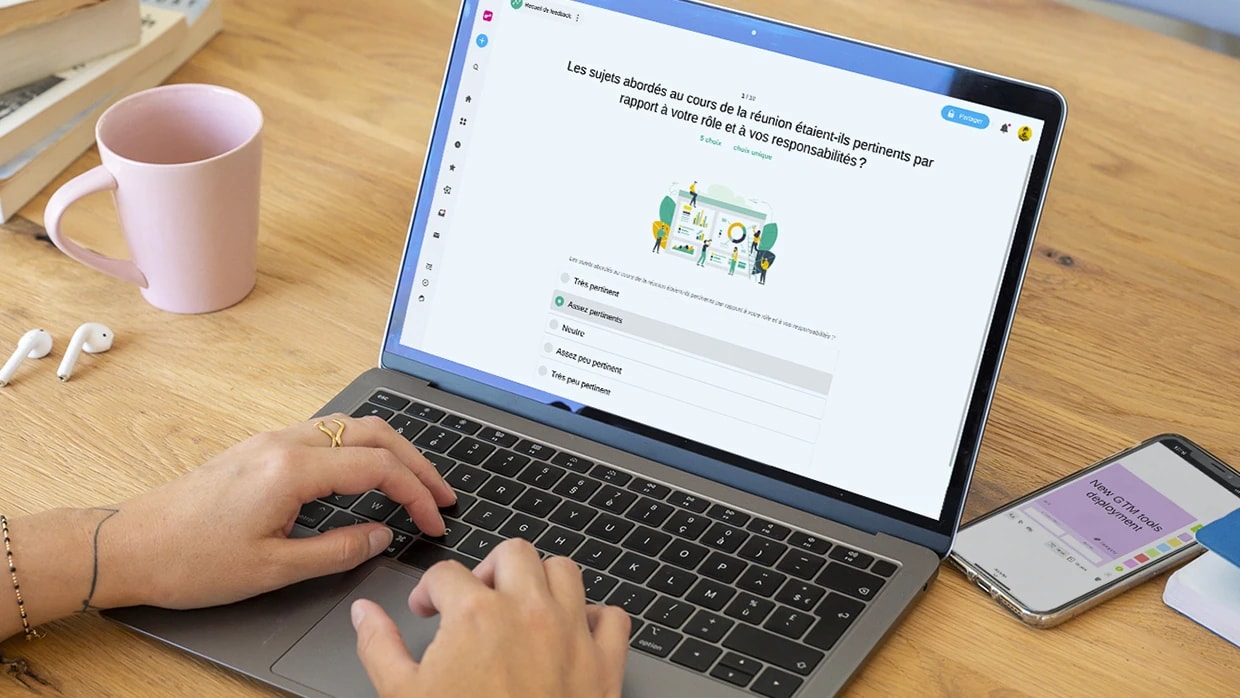 Une personne travaillant sur un ordinateur qui affiche un Sondage “Recueil de feedback”. | Klaxoon