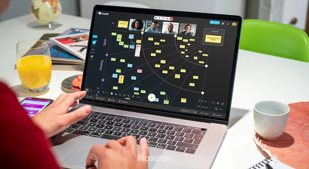 A person working on a computer displaying a Klaxoon "Transformation Map" Board completed with ideas. | Klaxoon