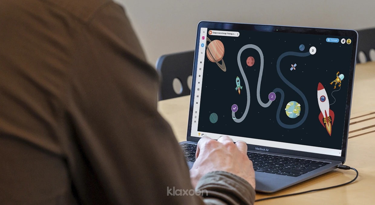 Une personne travaillant sur un ordinateur qui affiche un aperçu du template de Mission "Comprendre le Design Thinking en moins de 5 minutes". | Klaxoon