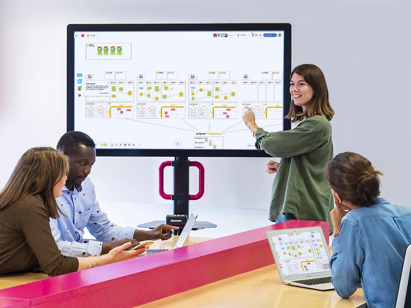 Equipe agile en réunion de planification avec post-it et ordinateur portable.