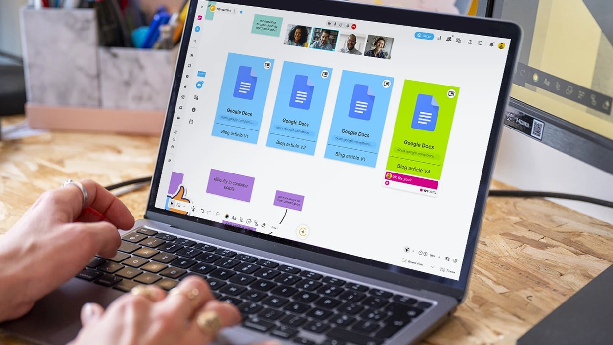 Une personne travaillant sur un ordinateur qui affiche plusieurs fichiers partagés sur un whiteboard. | Klaxoon