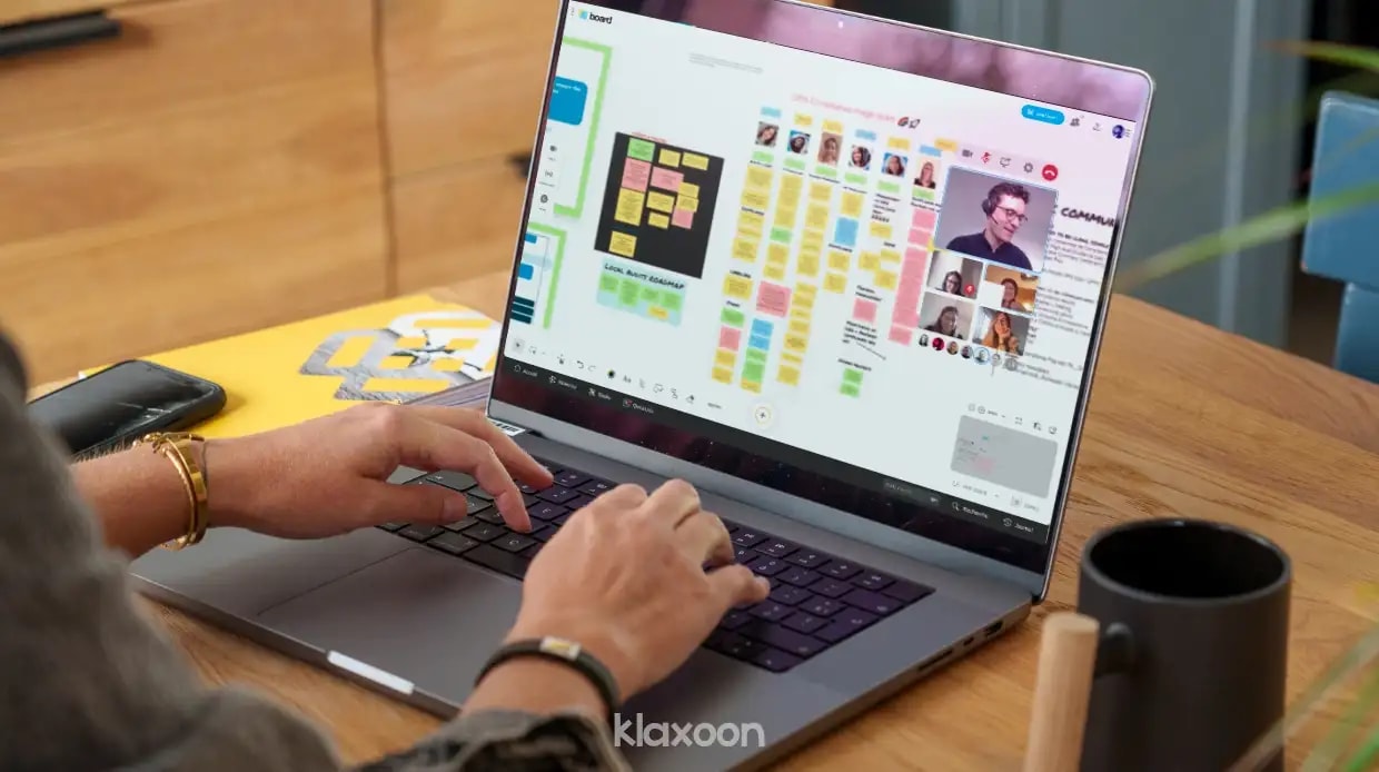 Une personne travaillant à distance sur un ordinateur affichant le Board d’équipe de Laura, et d’autres personnes connectées en visio. | Klaxoon