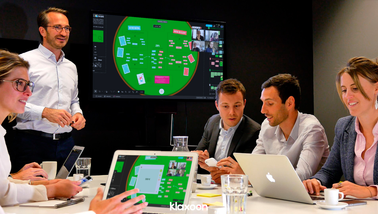 Un petit groupe de commerciaux en pleine séance de travail, échangent autour du template BATNA, accessible sur leurs écrans. | Klaxoon