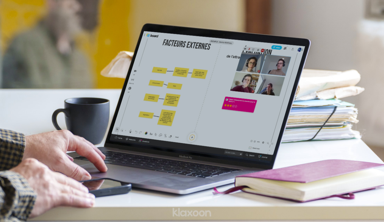 Un individu visualise l’analyse de la matrice McKinsey sur son écran d’ordinateur portable. Les facteurs externes sont listés sous la forme de vignettes colorées. En rose, le résultat de la Question d’évaluation indique 3 étoiles. | Klaxoon