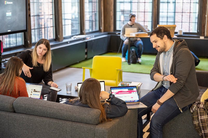 A group of four people sitting in sofas and discussing topics during a workshop. | Klaxoon