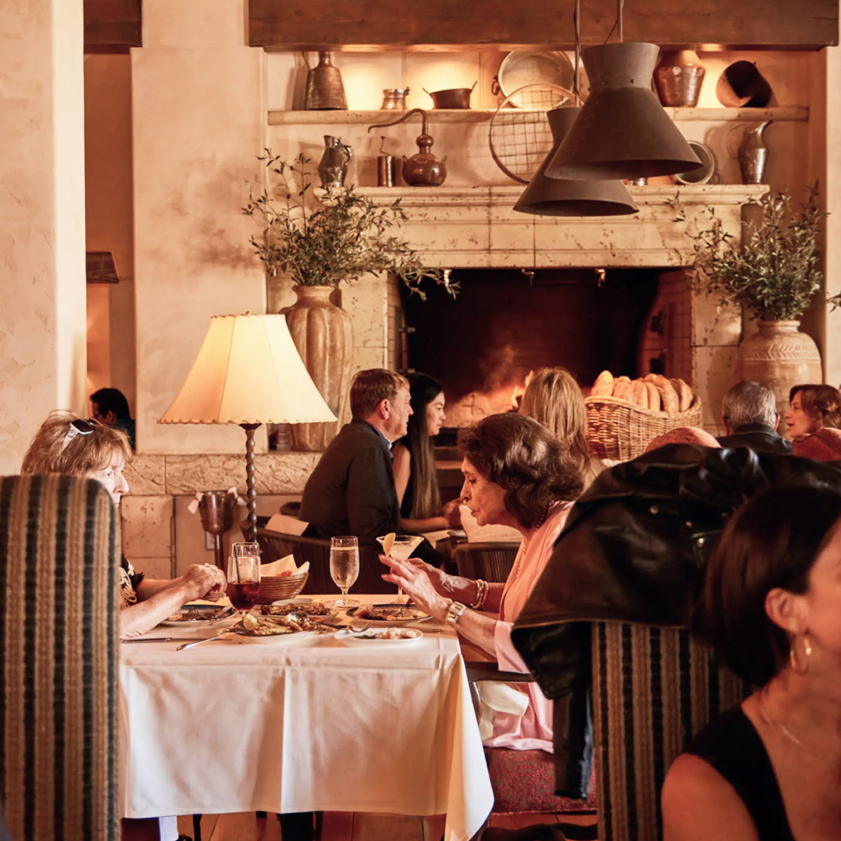 Elegant Mediterranean restaurant interior with warm lighting and stylish dining setup.