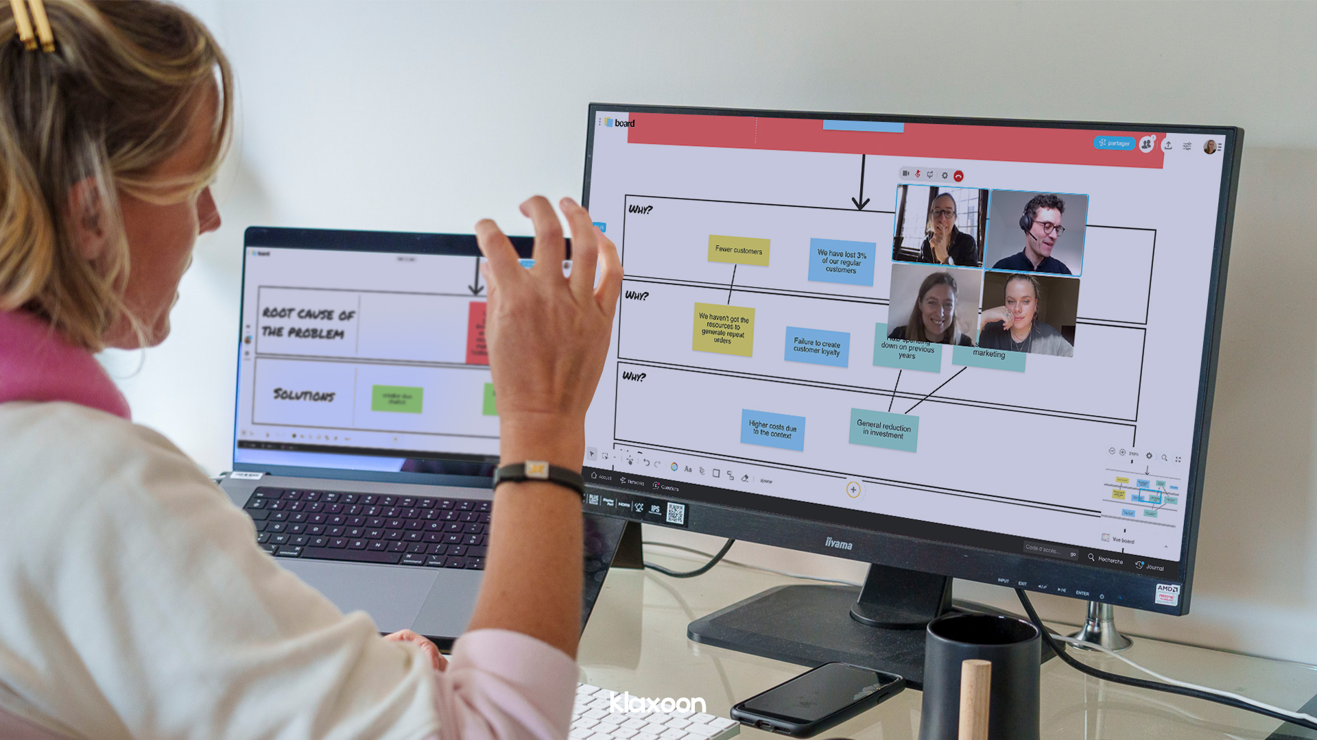A person working in remote on two screens, with 4 colleagues conneted on Board and working together on a "5 Whys" template. | Klaxoon