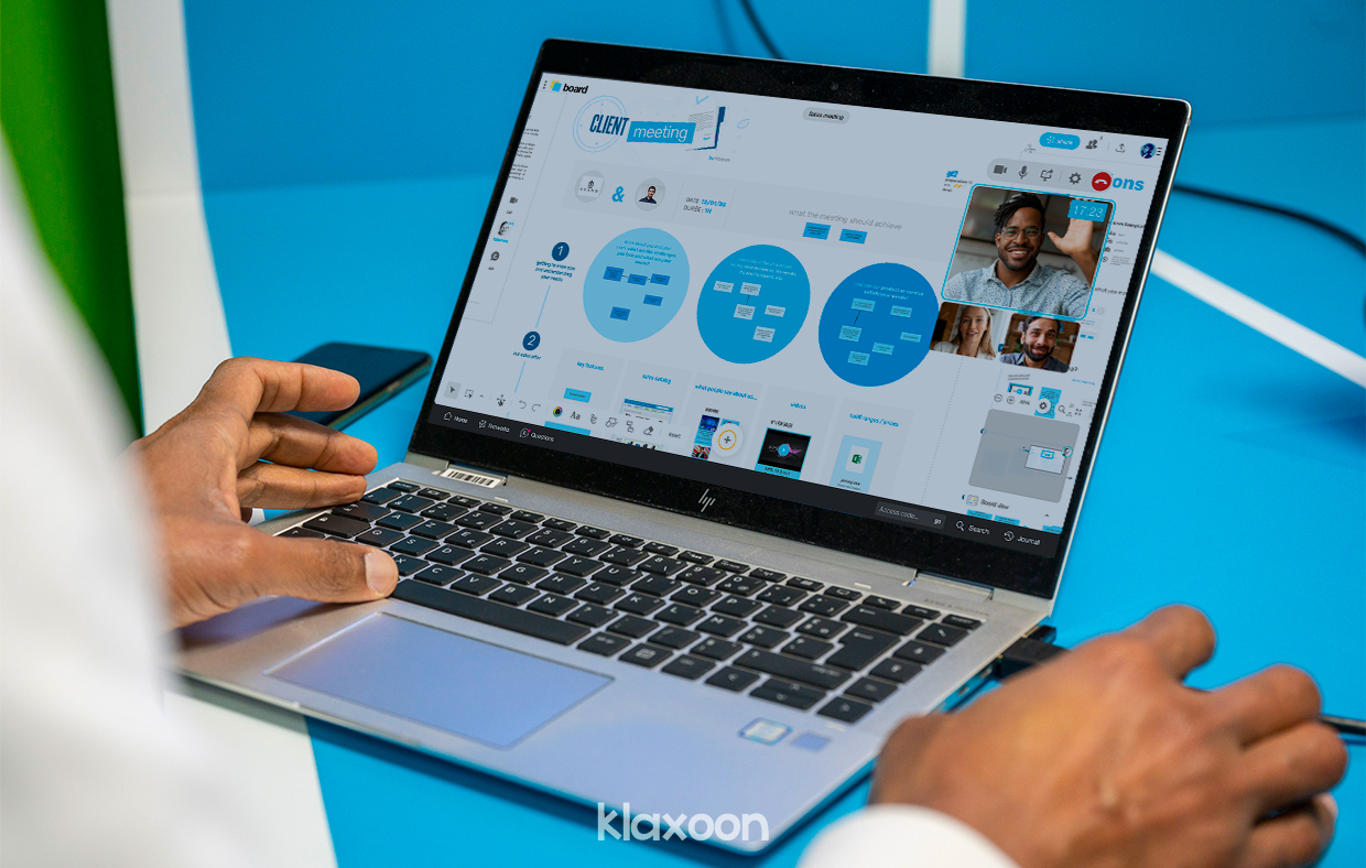 A person working on desktop remotely, with a Live session going on a Client Meeting template, with several people participating online. | Klaxoon 