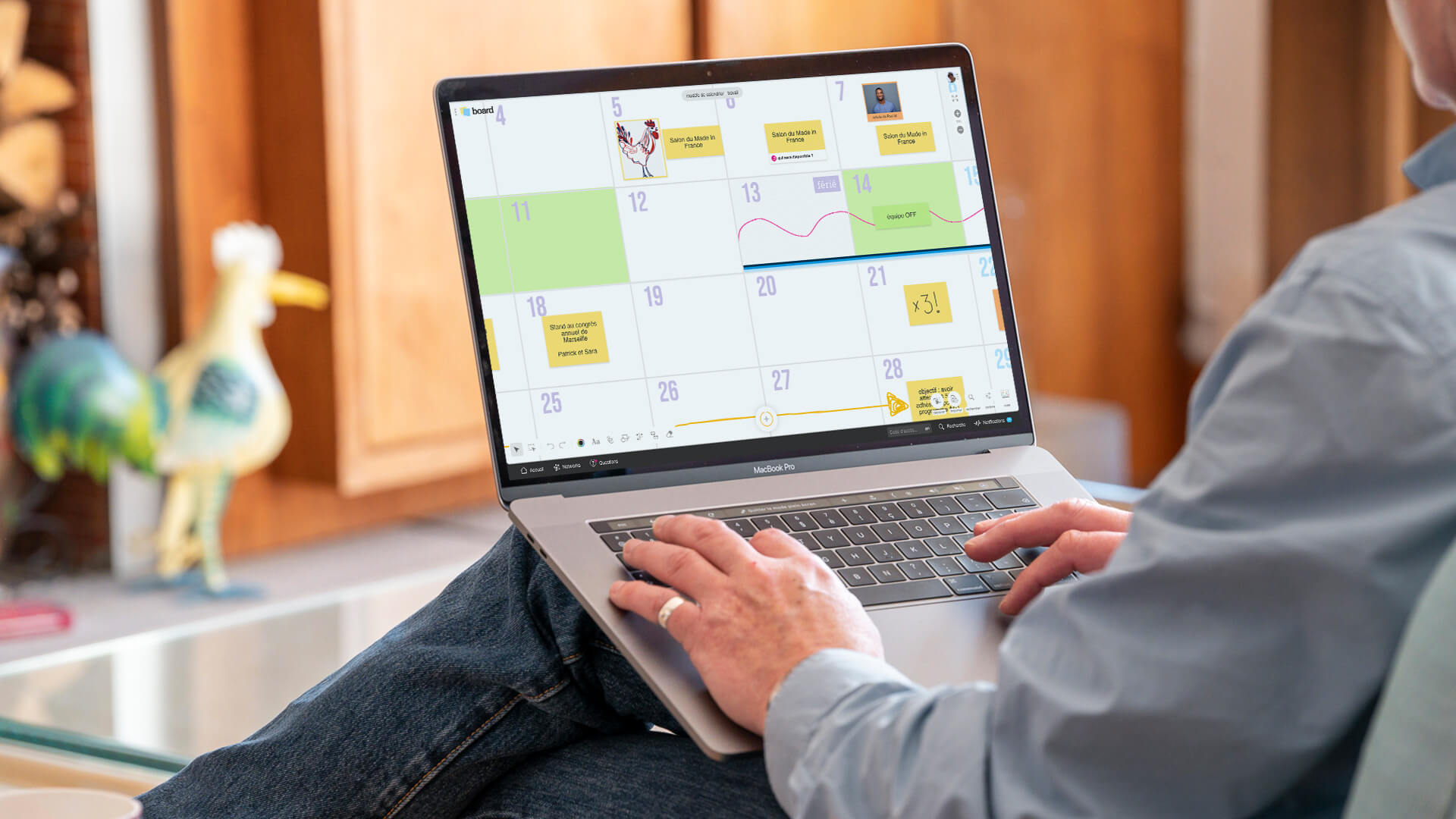 Une personne travaillant sur un ordinateur qui affiche un template Calendrier rempli. | Klaxoon